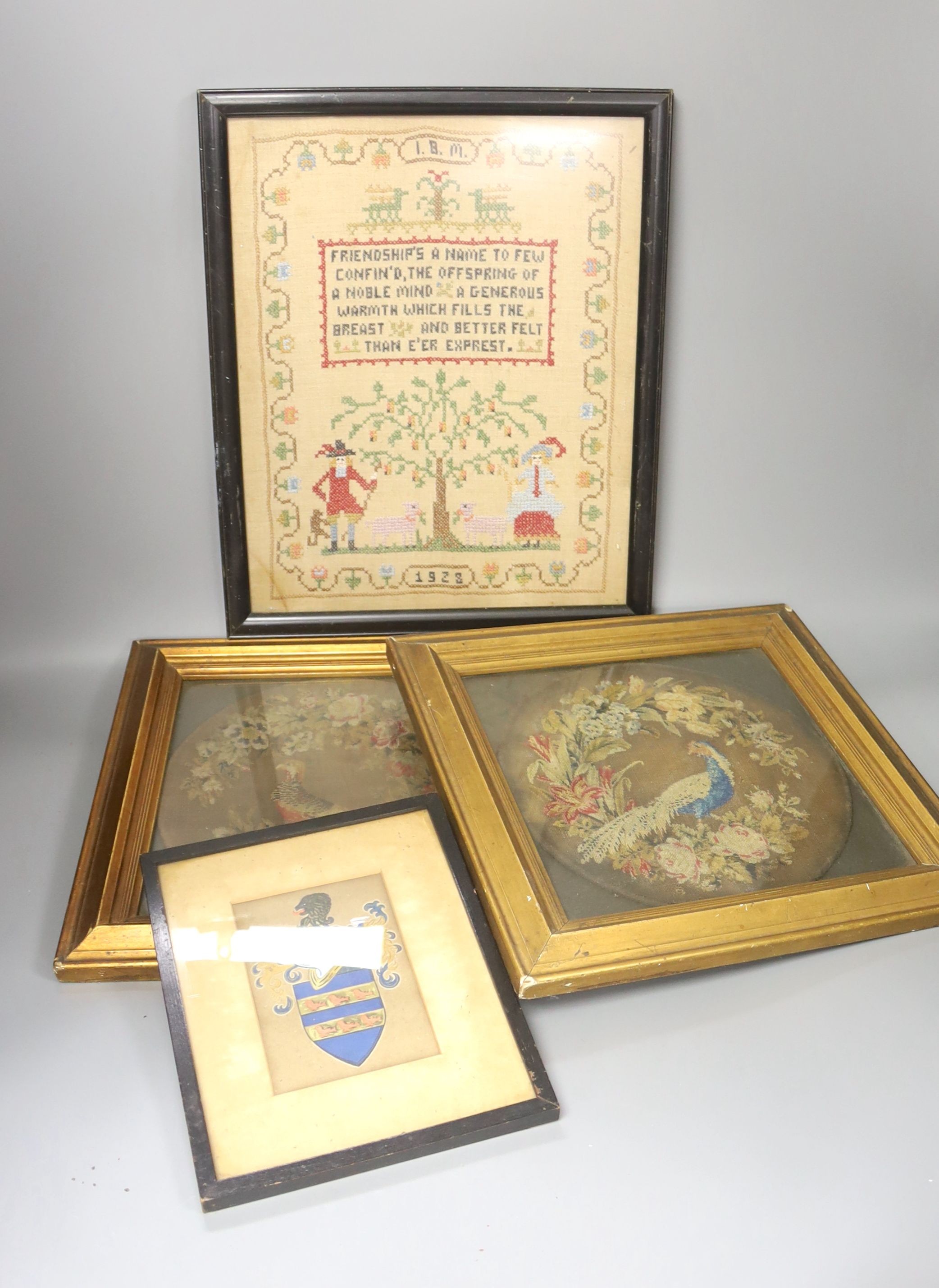 Pair of 19th century petit point face screens, a 1920s sampler and a heraldic panel, all framed.